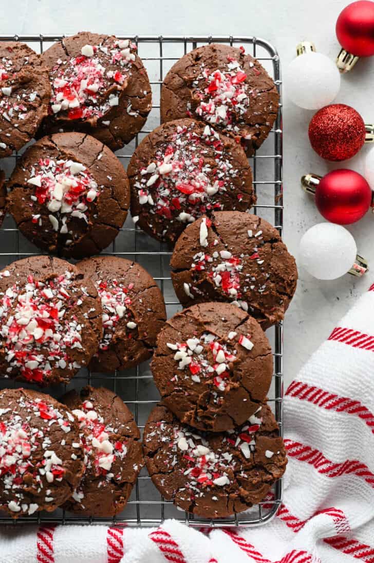 Chocolate Peppermint Cookies on a wire rack with small red and white bulb ornaments decorating the scene.
